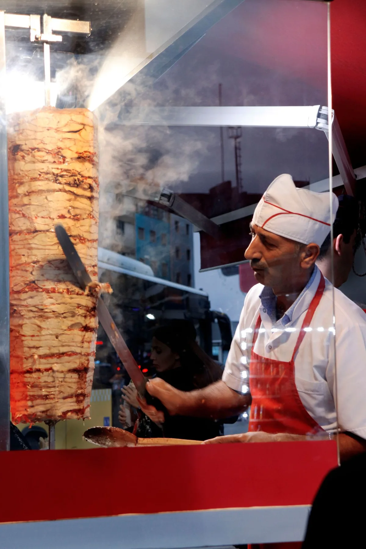 Chef carving fresh donair from the vertical spit